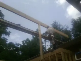 Carpenter setting a ridge beam over a new addition frame — Ice Dam Removal by Roofing Brothers in Canova