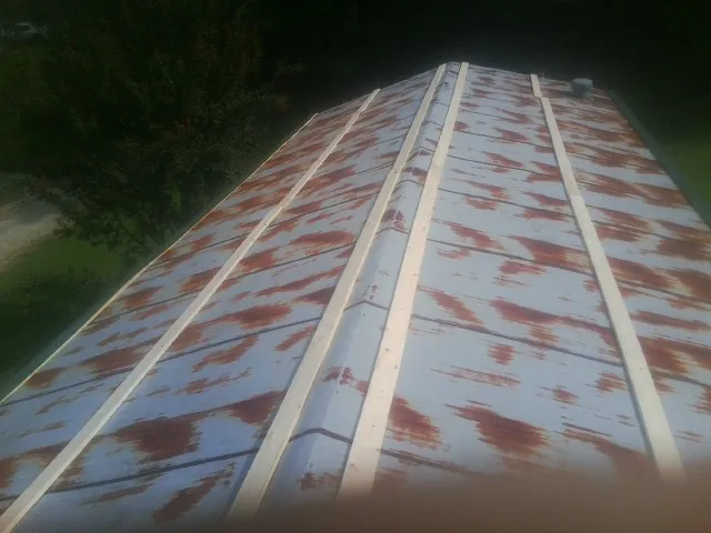 Rusted metal roof panels with new wood purlins before replacement — Storm Damage Roof Repair in Canova by Roofing Brothers