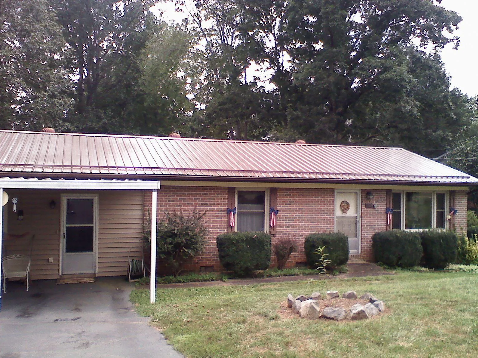 Bronze metal roof and carport on a brick ranch home — Roof Repair work by our crew in Canova