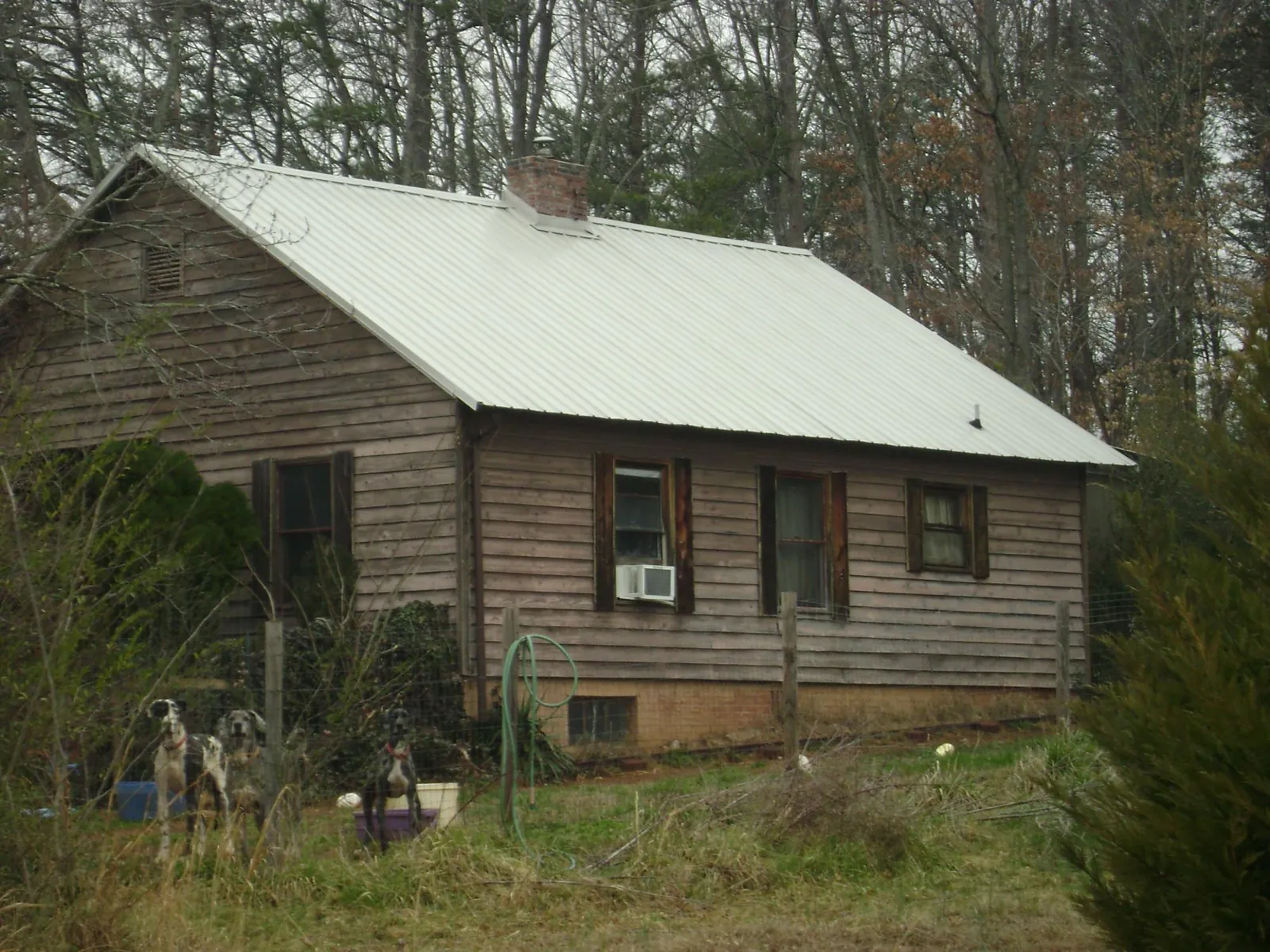 White metal roof on an old wood sided farmhouse, from a Metal Roof Installation job in Canova